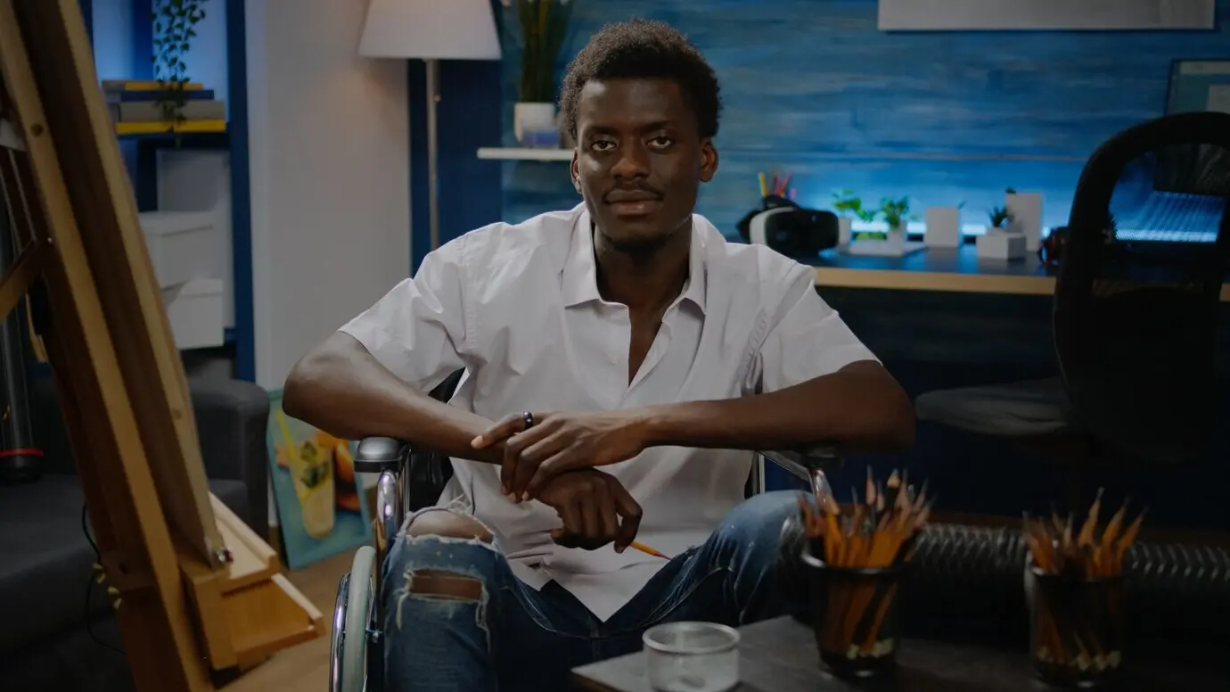 Schwarze junge kunstschaffende Person mit Behinderung, die Werkzeuge für modernes Zeichnen verwendet